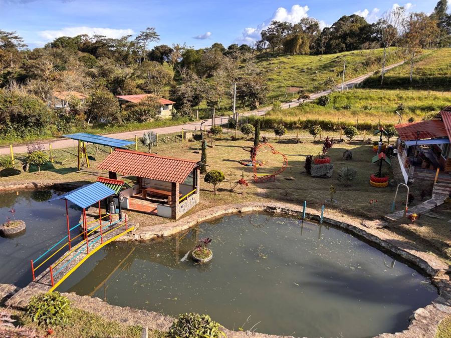 El lago de la finca, cruzado por el puente de colores, con el kiosco al lado